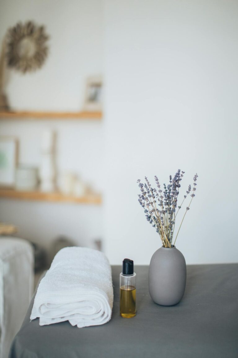 Relaxing spa scene featuring lavender, towel, and oil for a calming experience.